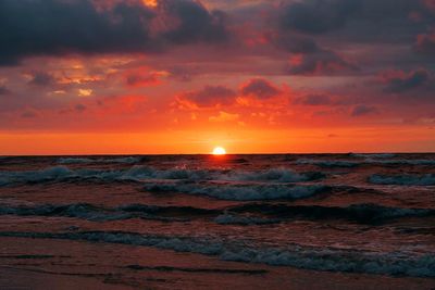 Sun shining through clouds over sea