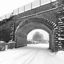 Road by bridge against sky during winter