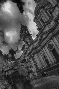 Low angle view of statues on building against sky