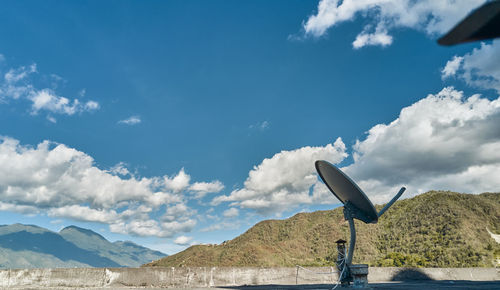 Satellite antenna with city and blue sky background, selective focus