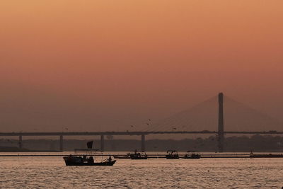 Bridge over river against sky during sunset