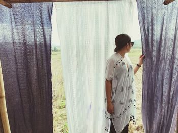 Young woman standing by window