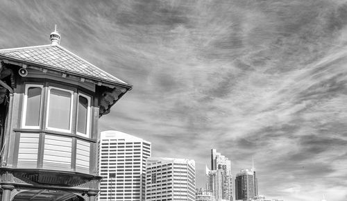 Low angle view of buildings against cloudy sky