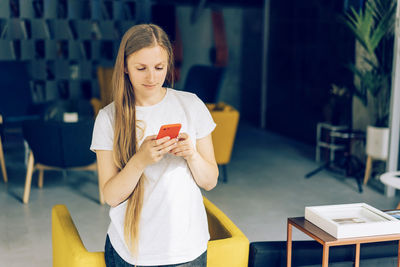 Full length of woman holding mobile phone