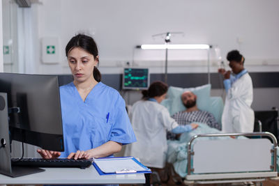 Nurse using desktop computer in ward room