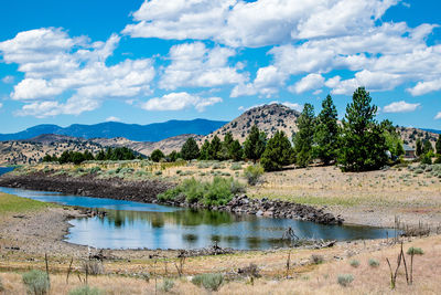 Lake by mountains against cloudy sky