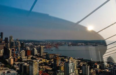 High angle view of city by sea against sky