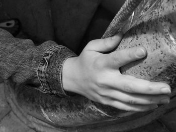 Close-up of woman hand on rock