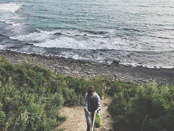 Woman climbing through rope at beach