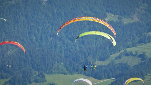 People paragliding against mountain