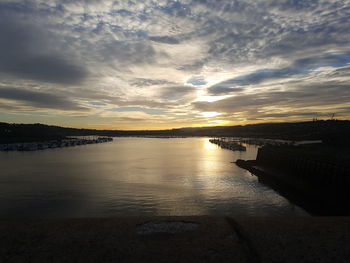 Scenic view of river against sky at sunset