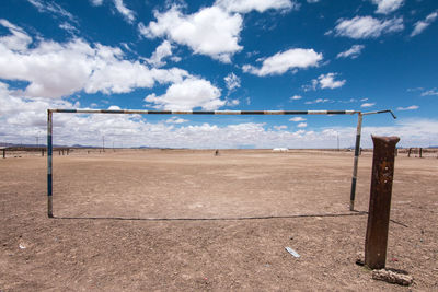 Soccer net at beach against sky