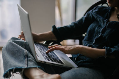 Midsection of man using laptop at home