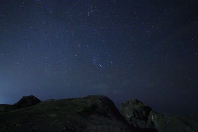 Low angle view of mountain against star field