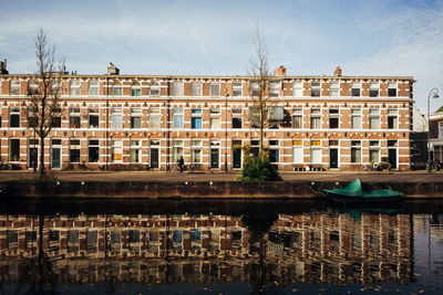 Reflection of building in river against sky