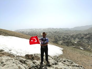 Man standing on mountain against clear sky