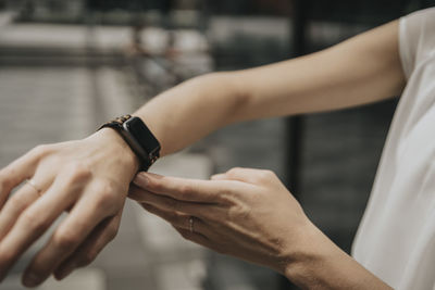 Young woman showing smart watch on sunny day