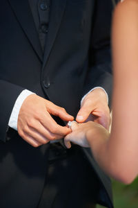 Midsection of bride holding wedding rings