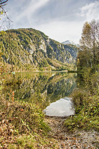 Scenic view of lake by mountain against sky