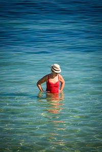 Full length of woman wearing hat in sea