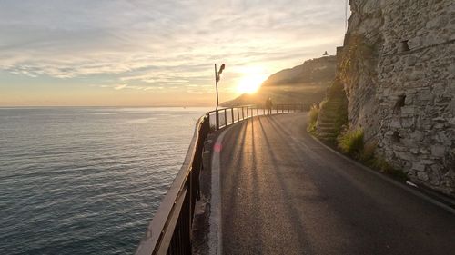 Pier over sea against sky during sunset