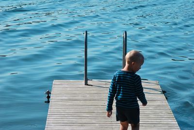 Rear view of woman on pier over lake