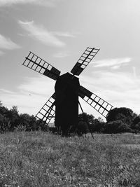Traditional windmill on field against sky