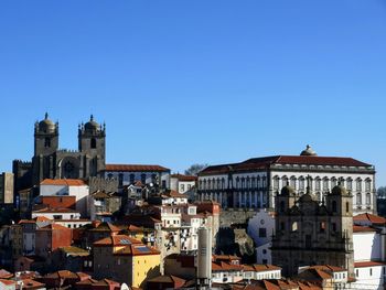 Buildings in city against clear blue sky