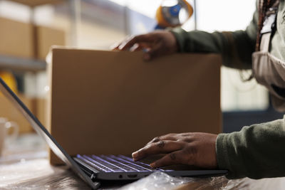 Midsection of woman using laptop on table