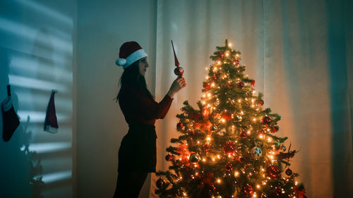 Girl makes christmas tree at home