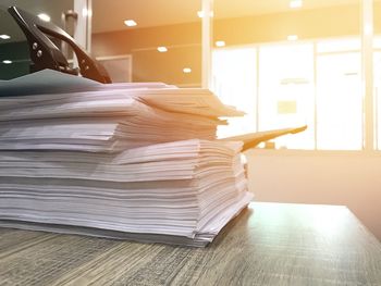 Close-up of stacked papers at desk in office