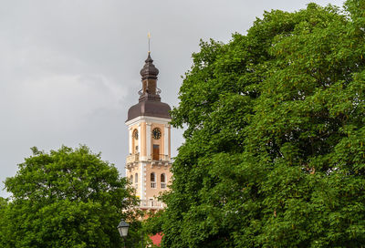 Low angle view of trees and building against sky