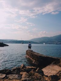 People sitting on rocks by river