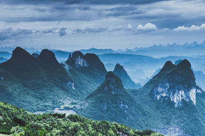 Scenic view of mountain range against cloudy sky