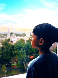 Rear view of boy looking against sky