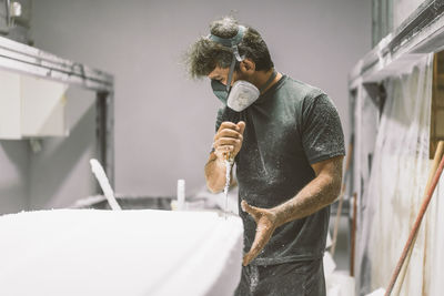 Mature man concentrating while shaping board