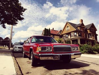 Red vintage car on street during sunny day