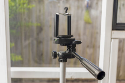 Close-up of electric lamp against glass door