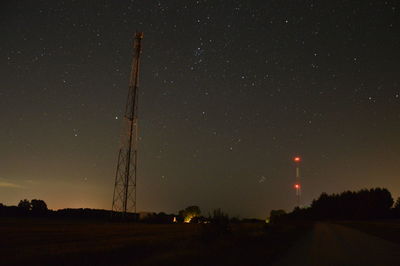 Low angle view of illuminated field against sky at night