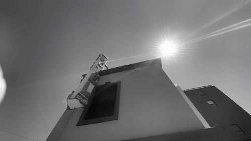 Low angle view of crane against sky on sunny day