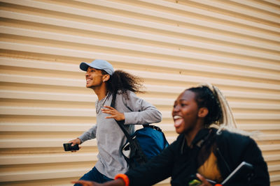 Happy man and teenage girl running by shutter