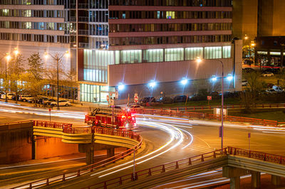 Emergency fire truck is parked on the city street with traffic light trails