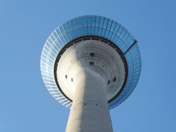 Low angle view of communications tower against blue sky