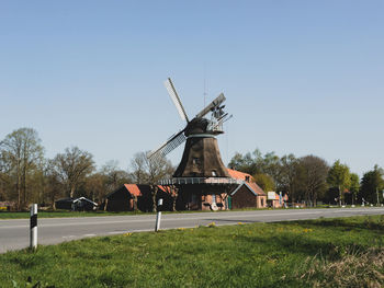 Traditional windmill on field against clear sky