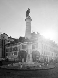 Statue of fountain in city against sky