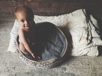 High angle portrait of cute baby relaxing on bed at home