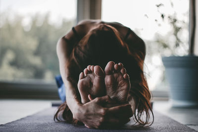 Woman doing yoga on floor at home