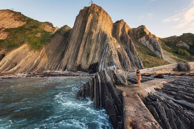 Panoramic view of rock formation in sea against sky