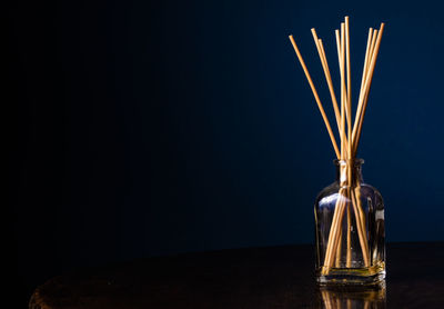 Close-up of incenses in glass jar against black background