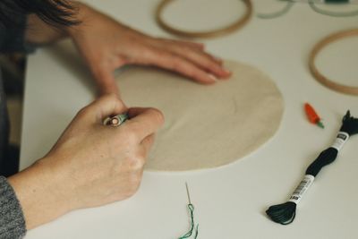 Cropped hands of woman making circle with pencil on paper